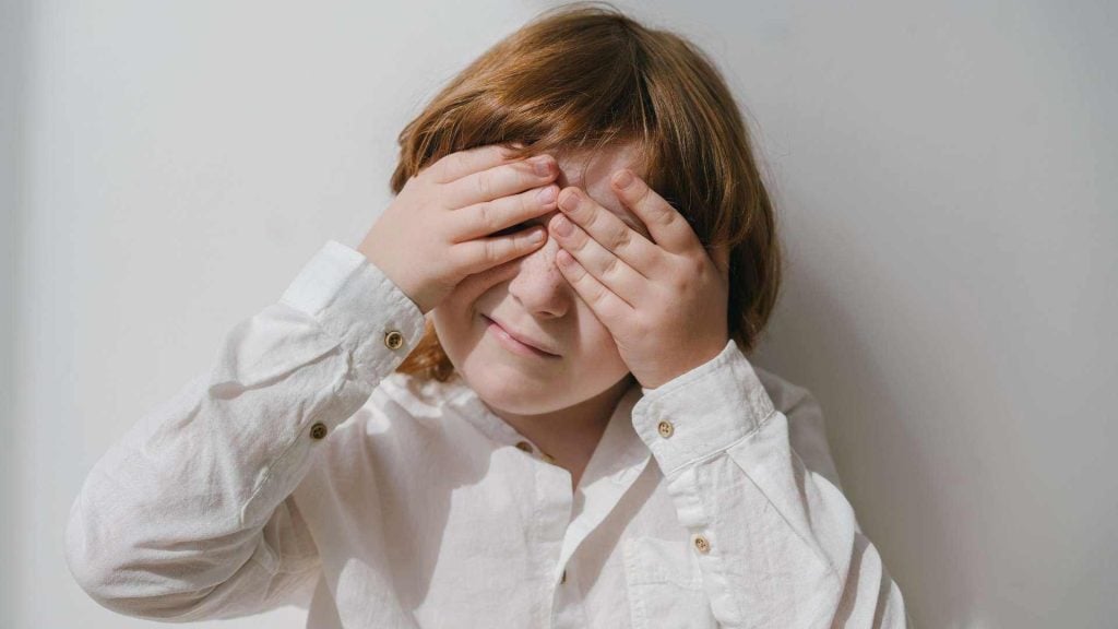 Child covering his eyes with his hands