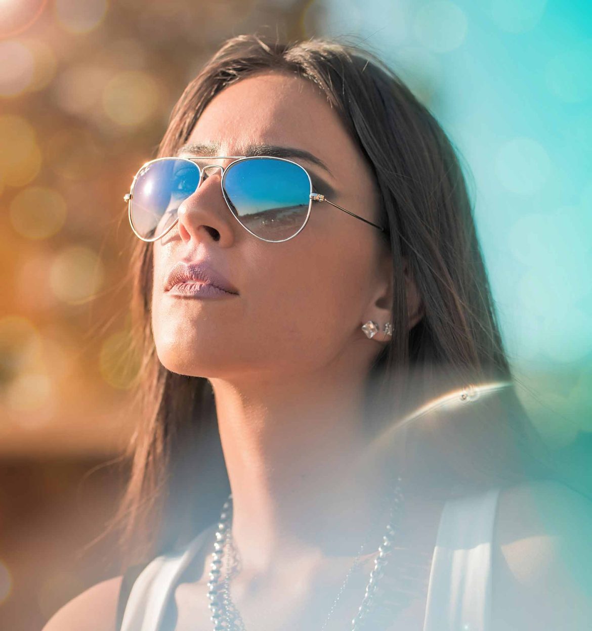 Long-haired woman staring at the sky in her aviator sunglasses