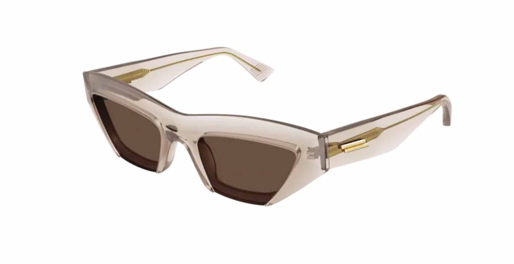 Sharp, rectangular cat-eye Bottega Veneta BV1219S sunglasses with thick transparent frames, gold detailing, and brown lenses